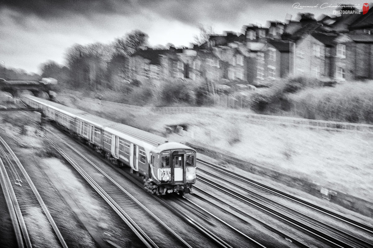 Flou filé partiel d'un train de banlieue se dirigeant vers le sud de Londres.