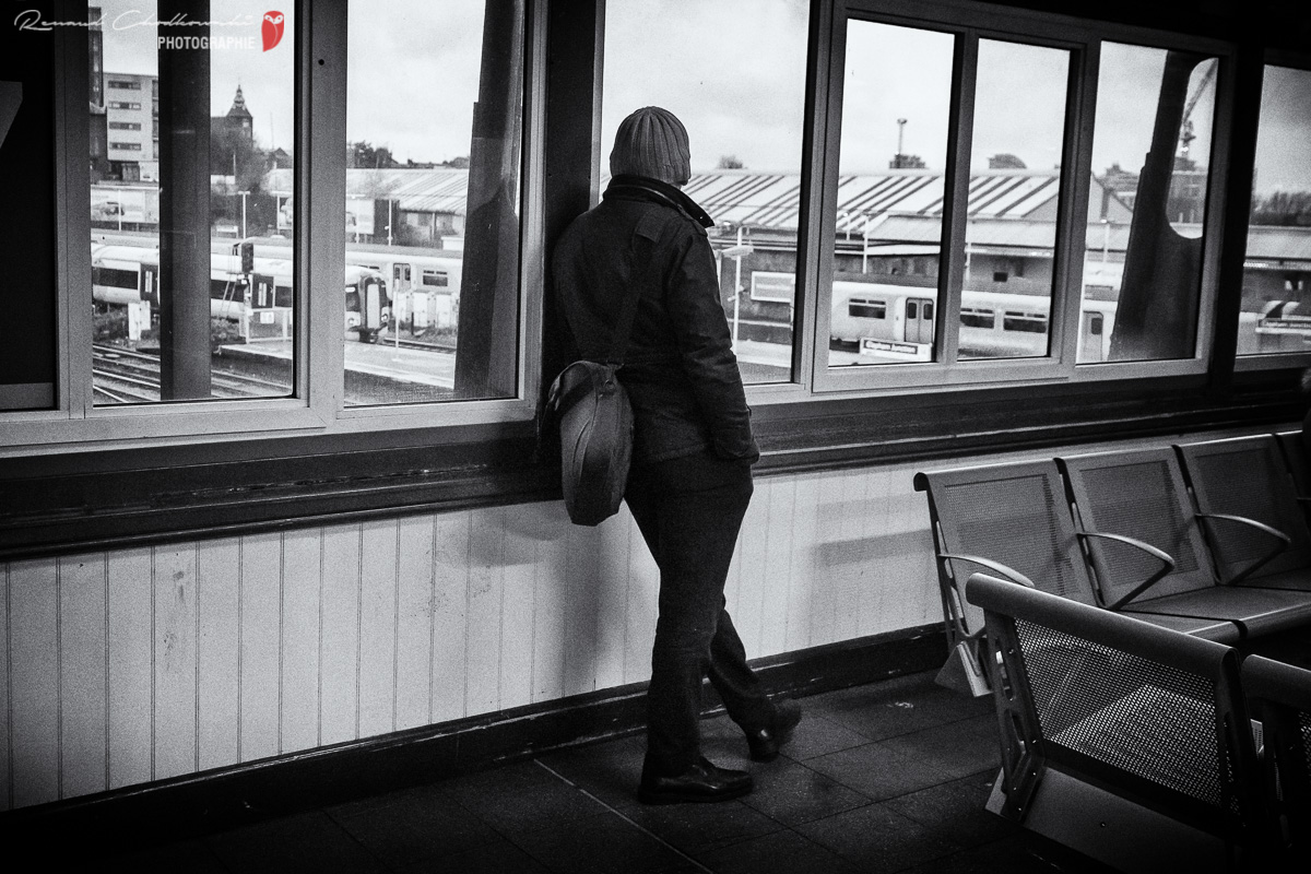 Un homme observe les trains depuis la passerelle principale de la gare de Clapham Junction.